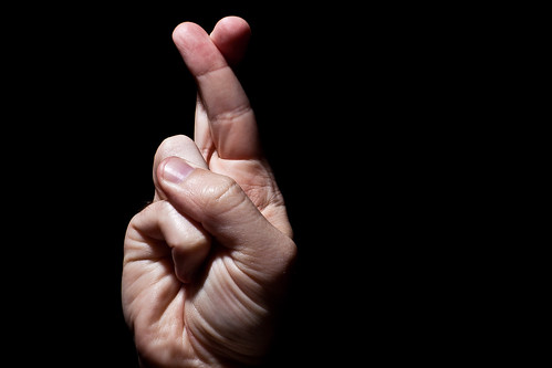 Image of a hand with fingers crossed